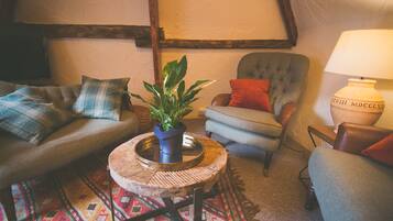 A cozy living room with a sofa, armchair, and a small round table with a plant.