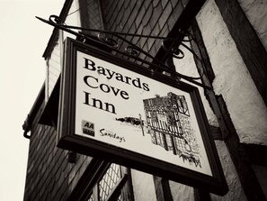 A sign for Bayards Cove Inn, featuring a black and white illustration of a building.