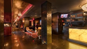 A modern lobby with a reception desk, seating area, and a bar.