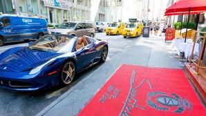 A red carpet with "Hotel New York" text and a logo, a blue sports car, and a blue van with "tyco" branding.