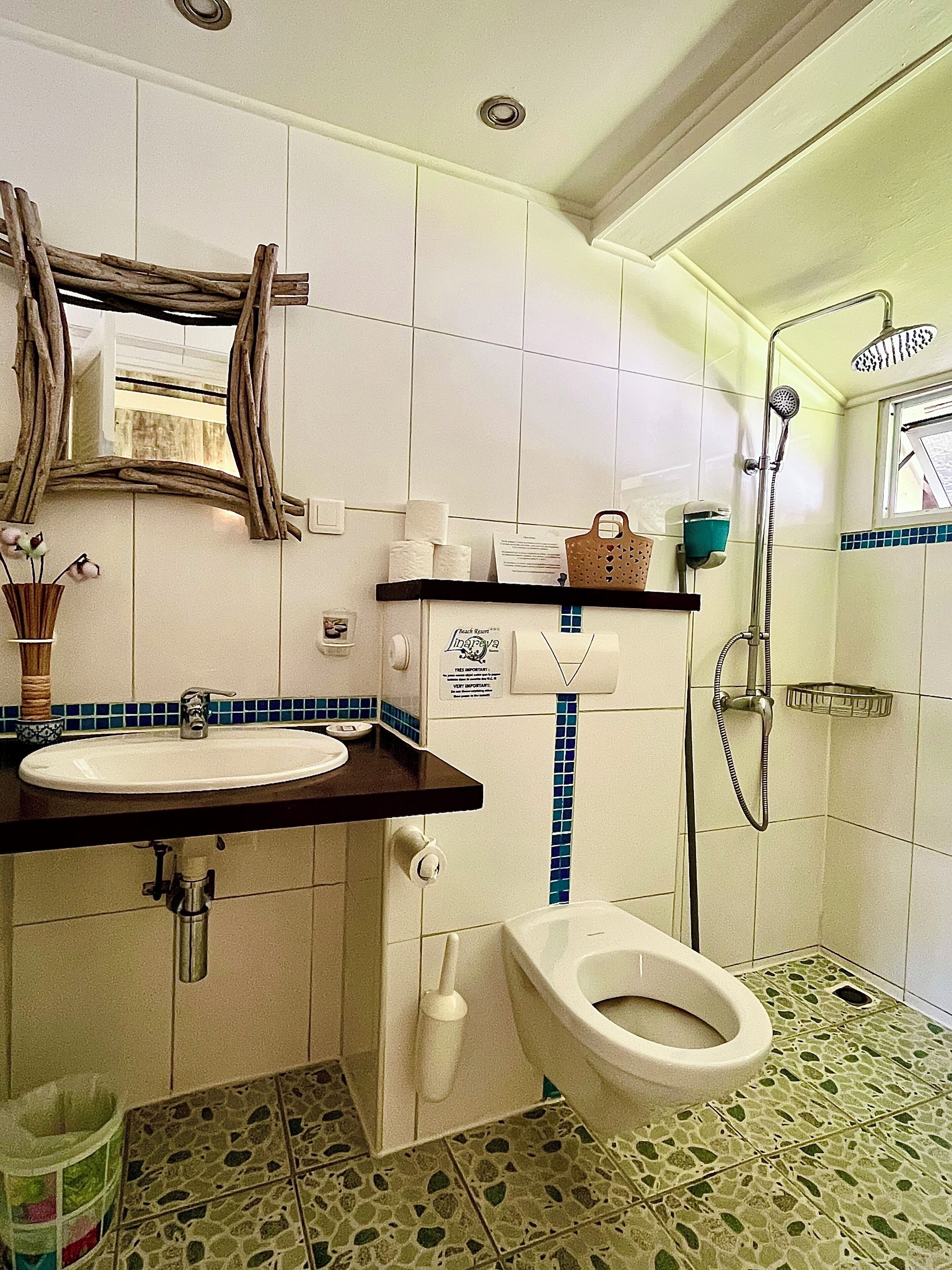 A bathroom with a sink, toilet, and shower.