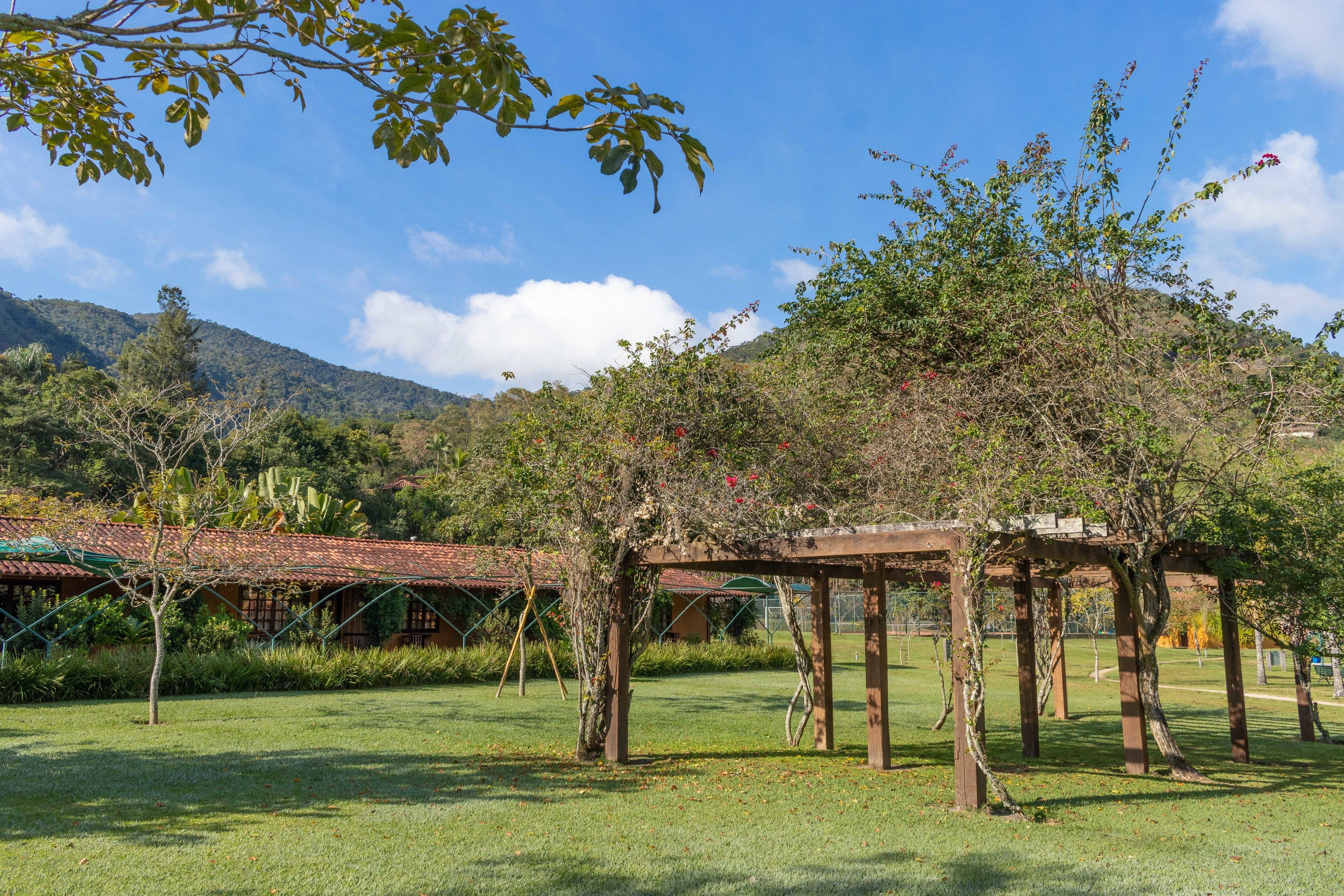 A gazebo in a park with a clear sky and mountains in the background.