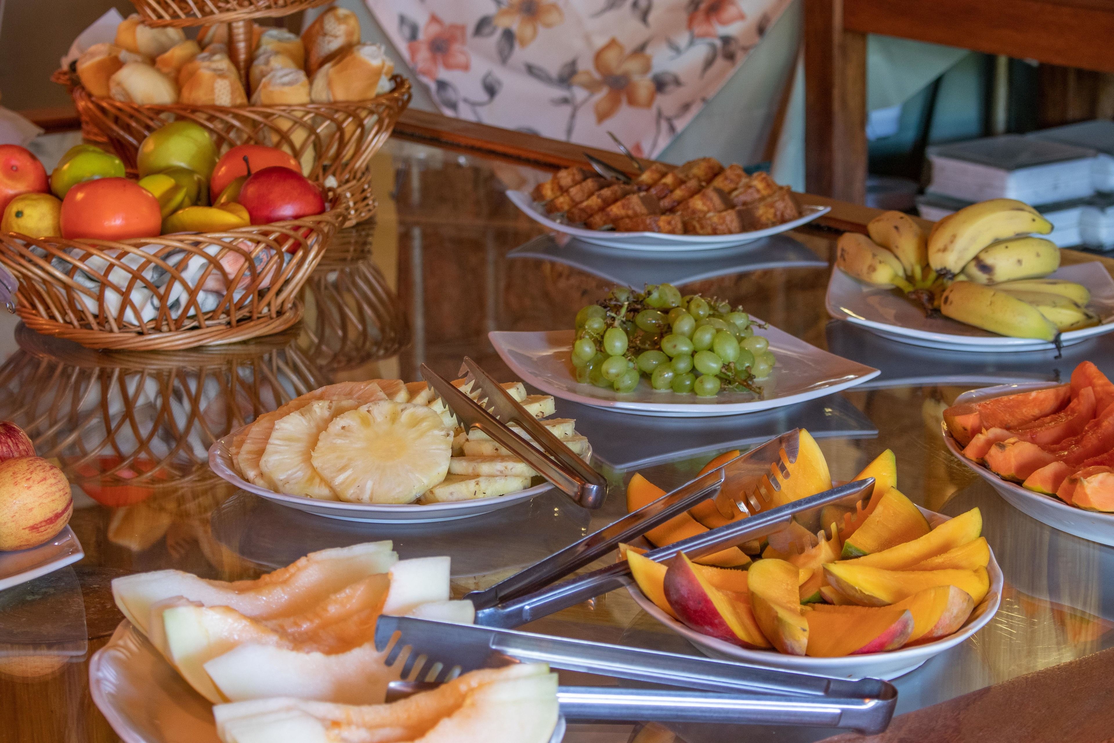 A buffet table with various fruits and pastries.