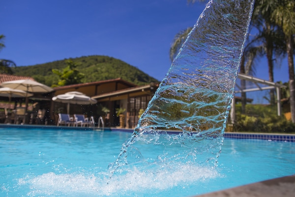 Una piscina al aire libre, sombrillas, tumbonas