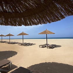 On the beach, white sand, beach cabanas, sun loungers