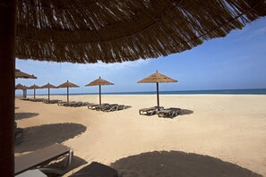 Plage, sable blanc, cabines (en supplément), chaises longues