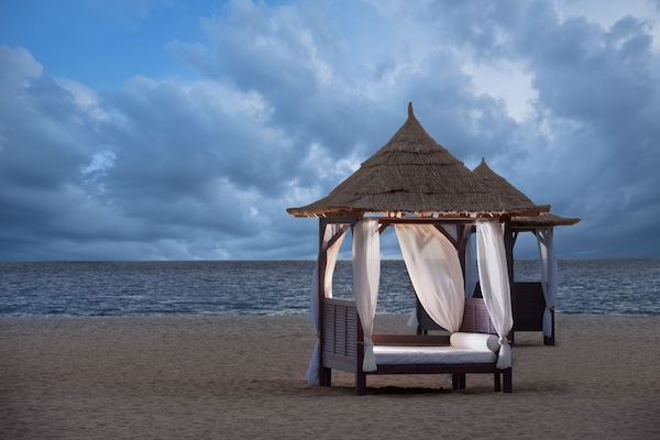 On the beach, white sand, beach cabanas, sun loungers