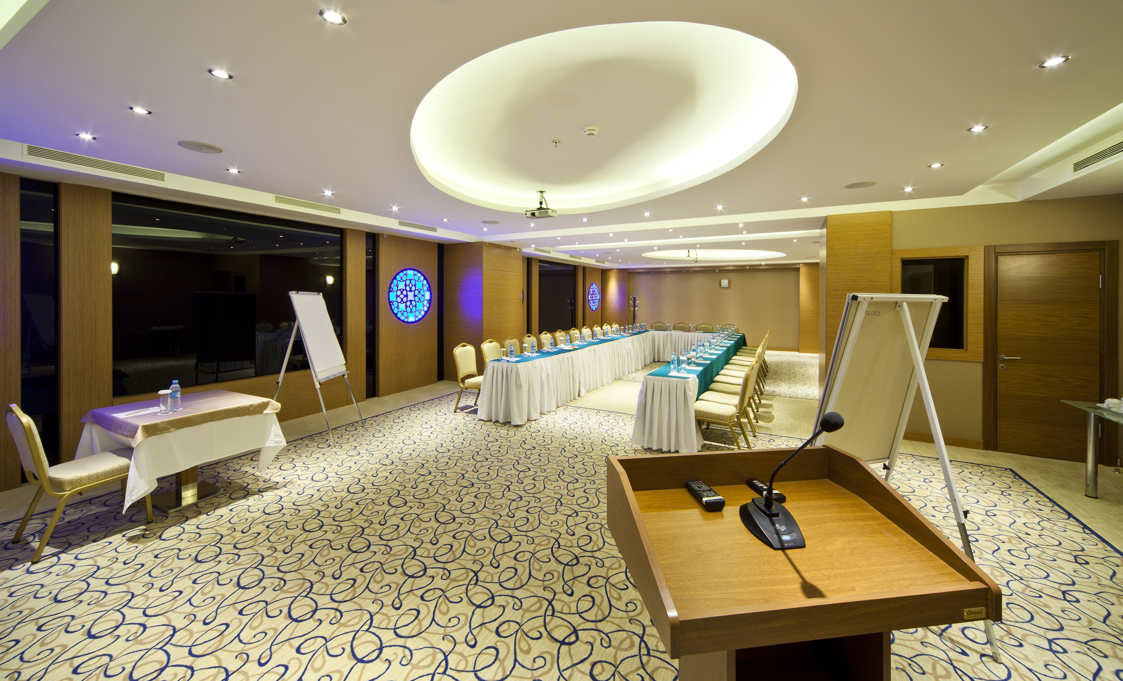 A conference room with a long table, chairs, a whiteboard, and a projector.