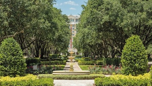 A garden pathway leading to a building with a fountain, surrounded by trees and manicured bushes. - WorldMark Reunion (Kissimmee)