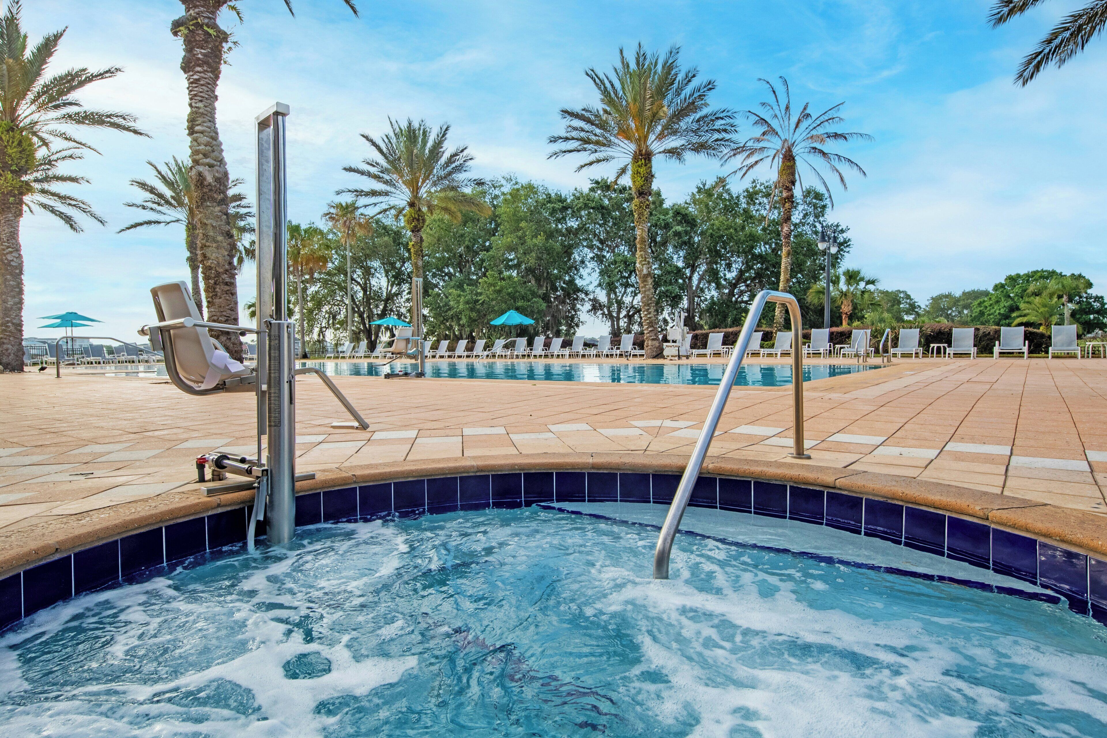 Un área de piscina con sillones de descanso y un jacuzzi.