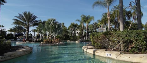 A clear pool surrounded by palm trees and a sign indicating a 3 ft depth.
