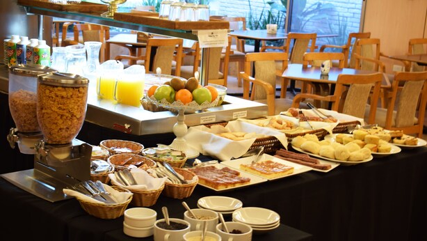 A buffet with various food items, including fruits, pastries, and cereals. - Hotel Solans Republica (Rosario)