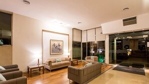 A modern living room with a sofa set, a coffee table, and a framed picture on the wall. - Hotel Solans Republica (Rosario)