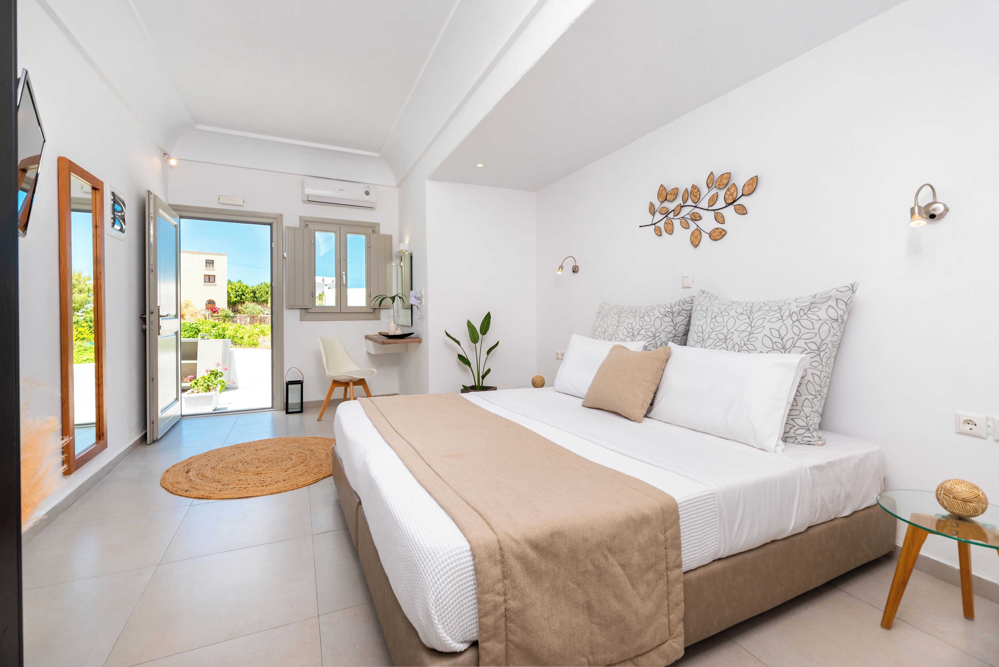 A bedroom with a bed, a bedside table, a chair, a window, and a door leading to a balcony.
