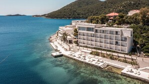 A coastal hotel with a pool area, multiple balconies, and a view of the sea. - Aminess Lume Hotel (Smokvica)