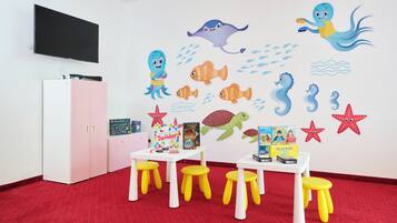 Children can play and learn in this colorful playroom featuring a vibrant wall mural and a flat-screen TV.