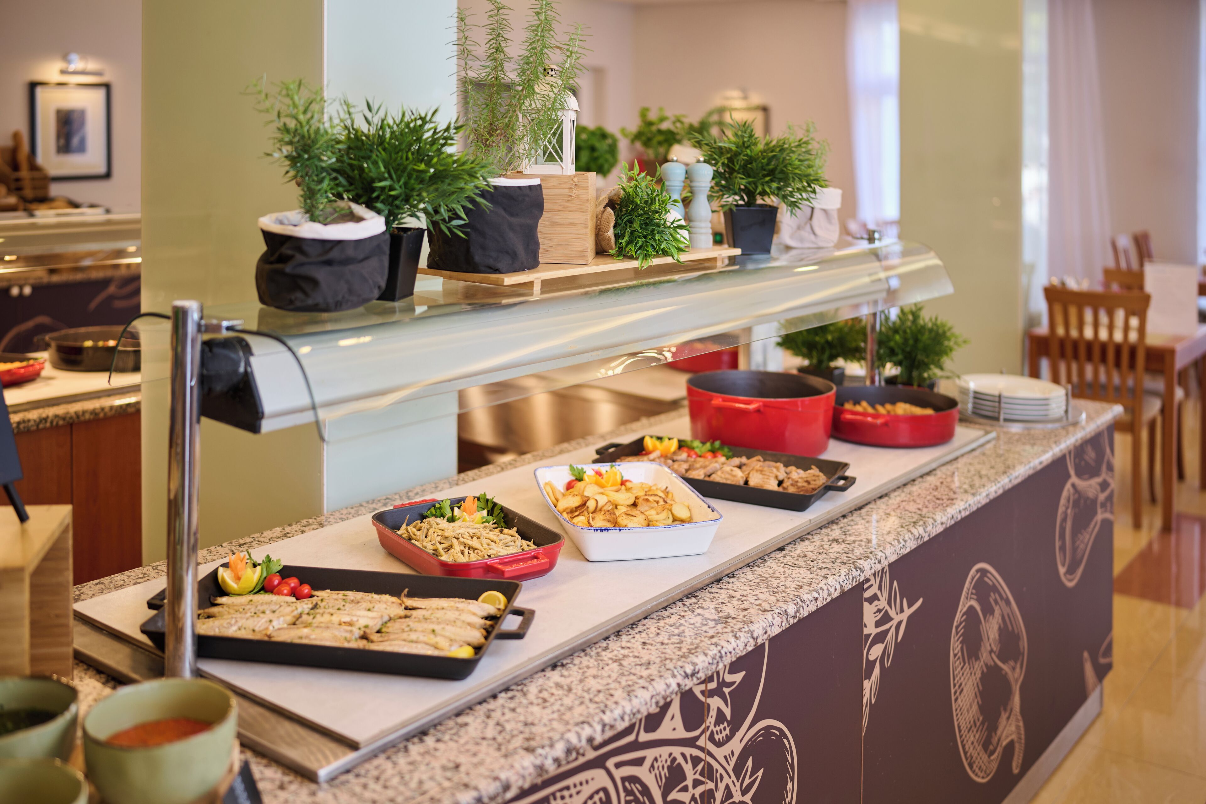 Ein Buffet mit verschiedenen Speisen und Zimmerpflanzen auf einer Theke.