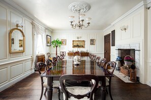Formal dining room with a long table, upholstered chairs, and a fireplace.