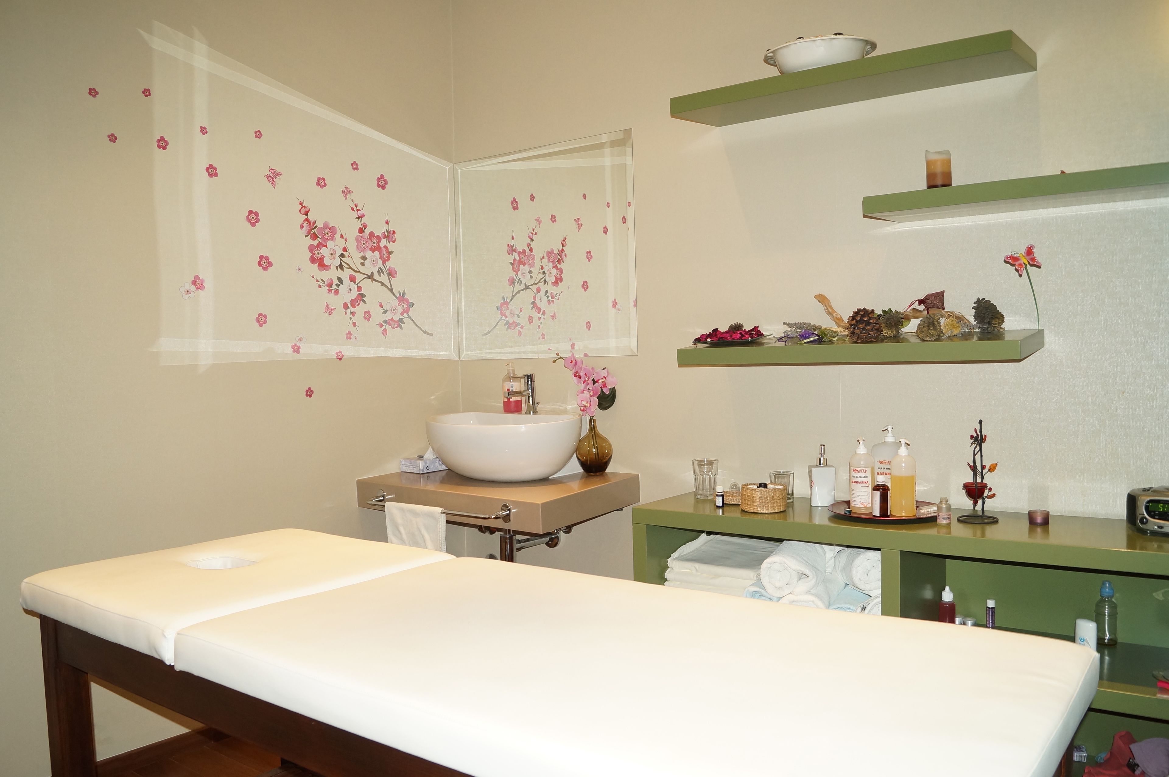A modern bathroom with a large mirror, a white sink, and a wooden bench.