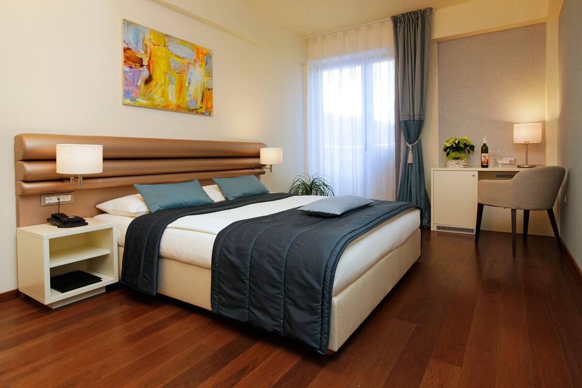 Une chambre d’hôtel moderne avec un grand lit, des tables de chevet, un bureau et une chaise.