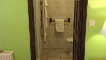 Un bagno con il water, un portasciugamani e un termosifone.