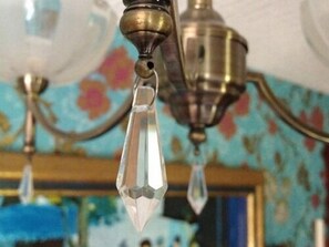 Un lustre orné de cristaux, suspendu à un élément fixé au plafond.