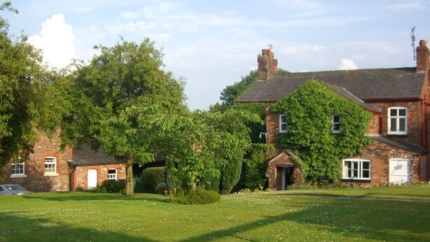 A large brick house with a well-maintained lawn and mature trees. - Ash Farm Country Guest House (Altrincham)