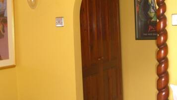 Una habitación con un armario de madera, un interruptor de luz y un cartel en la pared.