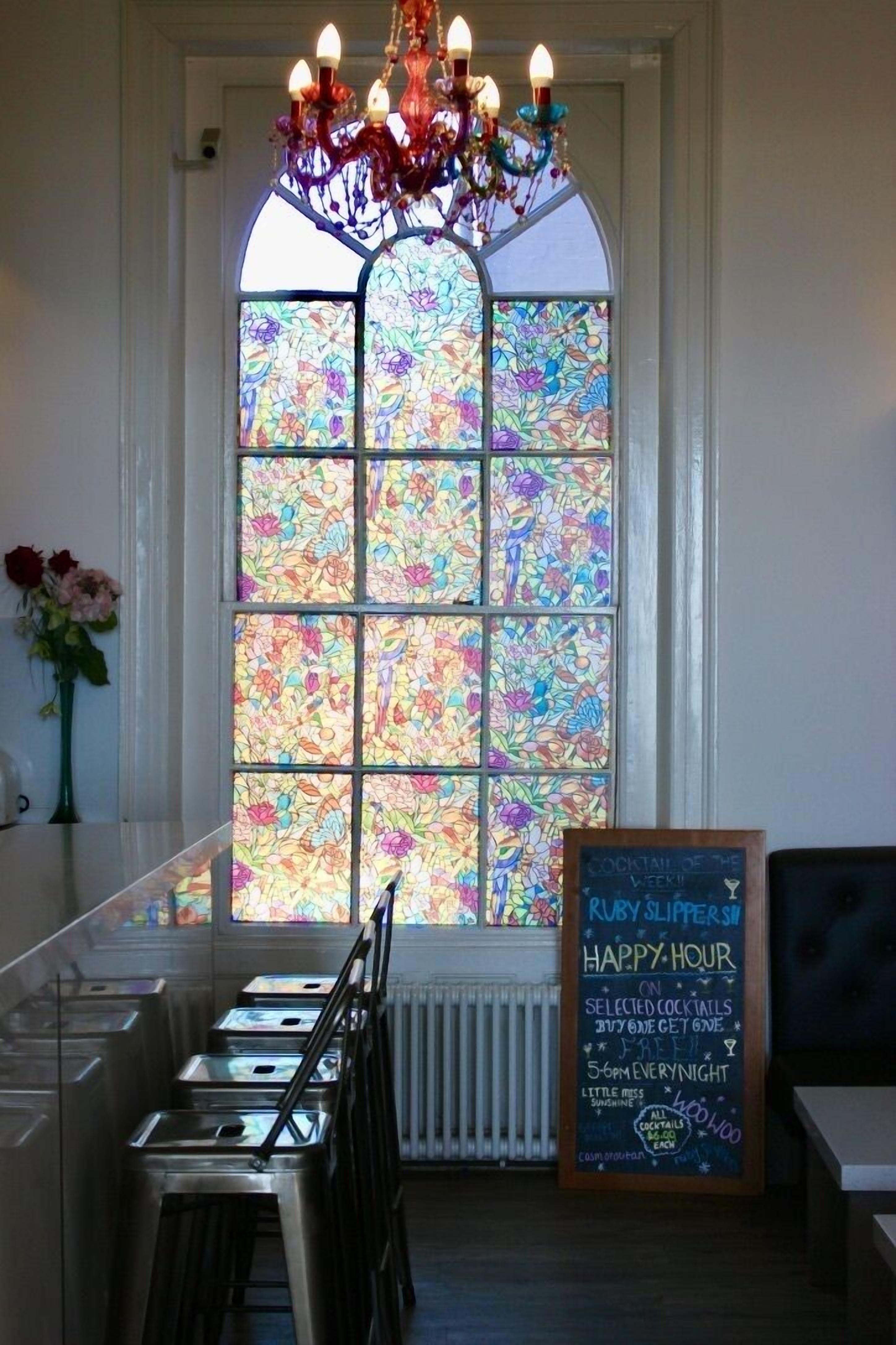 Un coin bar accueillant, agrémenté d’un vitrail, d’un tableau noir servant de menu et d’un lustre.