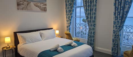 Habitación doble superior, vista a la playa | Escritorio, tabla de planchar con plancha y ropa de cama