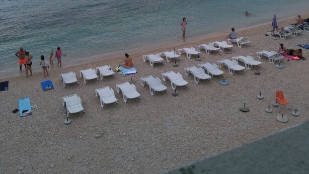 Una playa cerca, sillas reclinables de playa, sombrillas