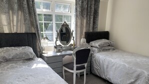A bedroom with two beds, a desk, and a chair. - Tower Hill Guest House (Basingstoke)
