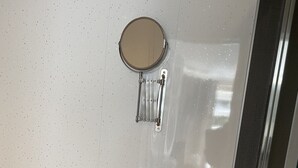 A bathroom with a white sink, a mirror, and a soap dispenser. - Tower Hill Guest House (Basingstoke)