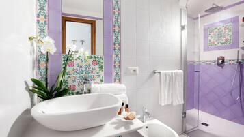 Un baño con un lavamanos ovalado grande, un bidé, una ducha y un espejo.