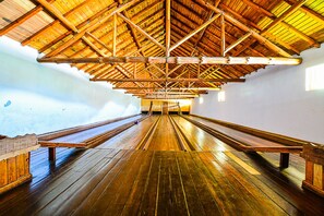 Una sala llarga i estreta amb taules de fusta i un sostre alt sustentat per bigues de fusta.