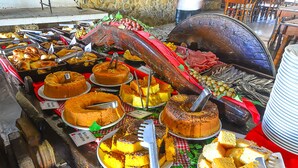Un bufé con diversos pasteles y dulces, incluyendo un pastel grande con un cuchillo para tallar.