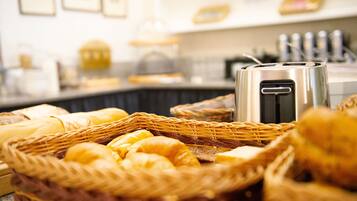 Ein Frühstücksbuffet mit verschiedenen Backwaren und einem Toaster.