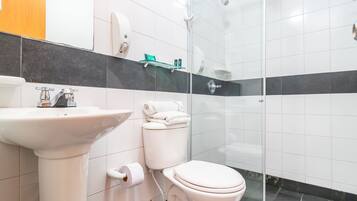 Ein modernes Badezimmer mit Waschbecken, Toilette und Duschkabine aus Glas.