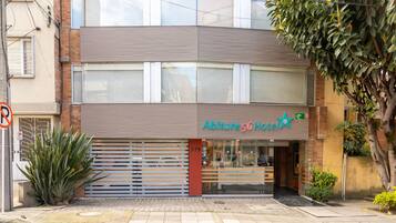 A two-story building with a sign for 'Abitare 56 Hotel'.