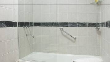 A bathroom with a glass-enclosed shower, a bathtub, a bidet, and a toilet.