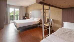 A modern hotel room with a large bed, a desk, a chair, and a balcony. - B&B HOTEL Saint-Jean de Luz (Saint-Jean-de-Luz)