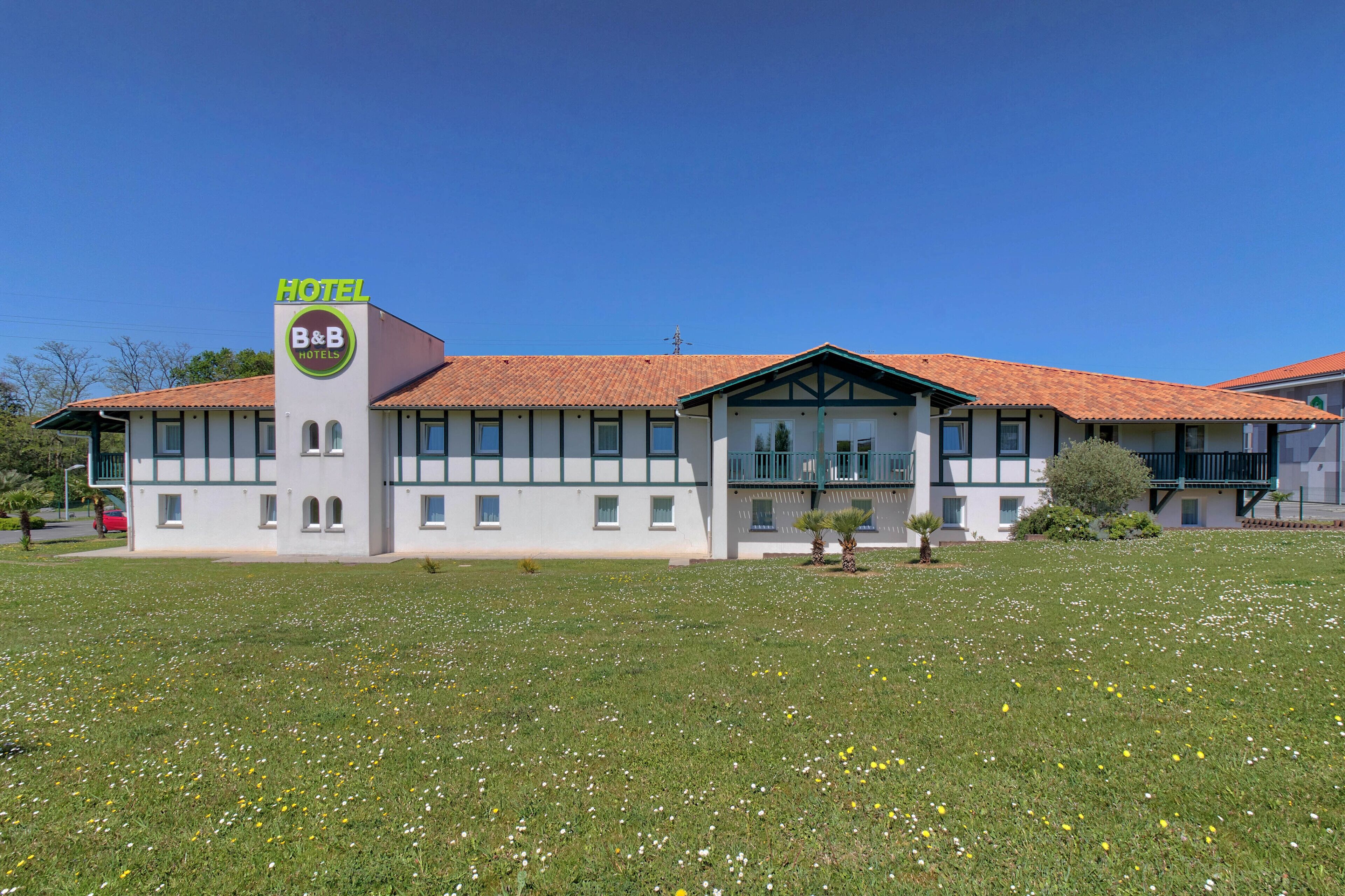A B&B hotel with a white facade, red-tiled roof, and a signboard.