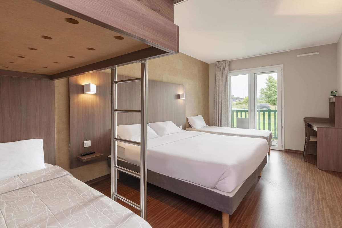 Ett hotellrum med två sängar, ett skrivbord och en balkong.
