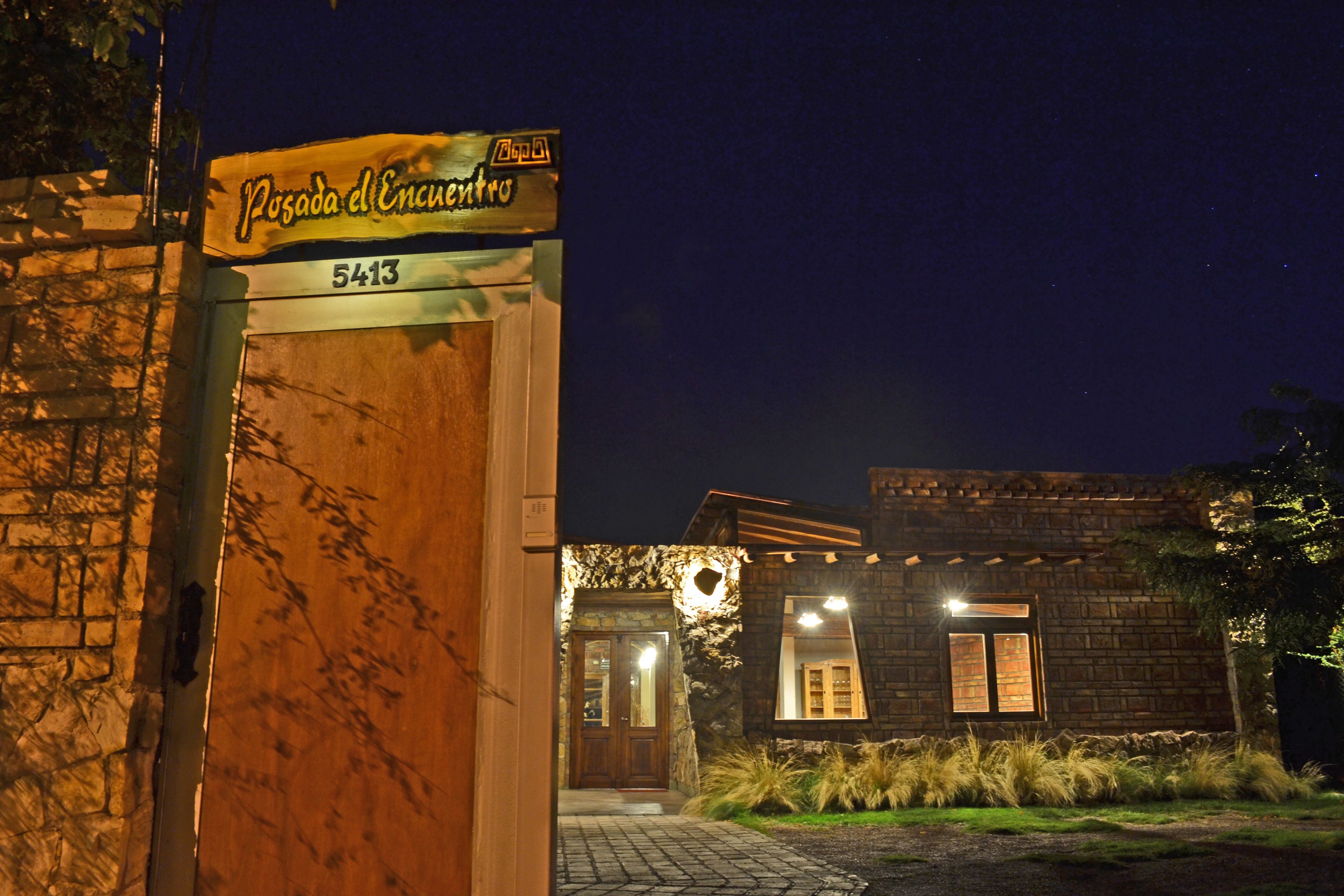 A stone building with a wooden door and a sign above it.