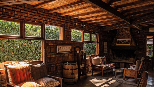 Un intérieur rustique avec des poutres en bois, une cheminée et un mur en pierre.