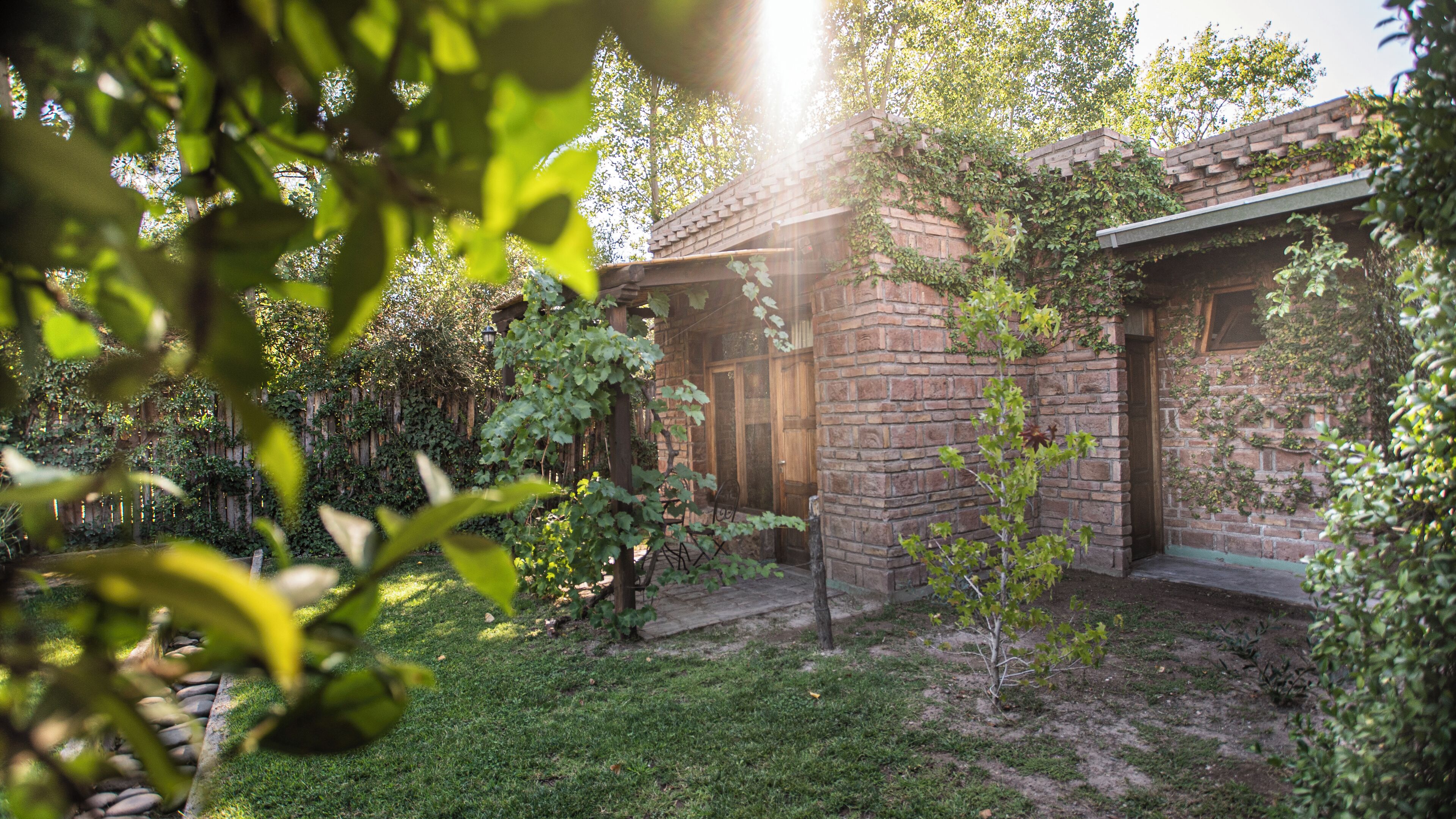 Ein Backsteinhaus mit einer Holzterrasse und einem kleinen Garten.