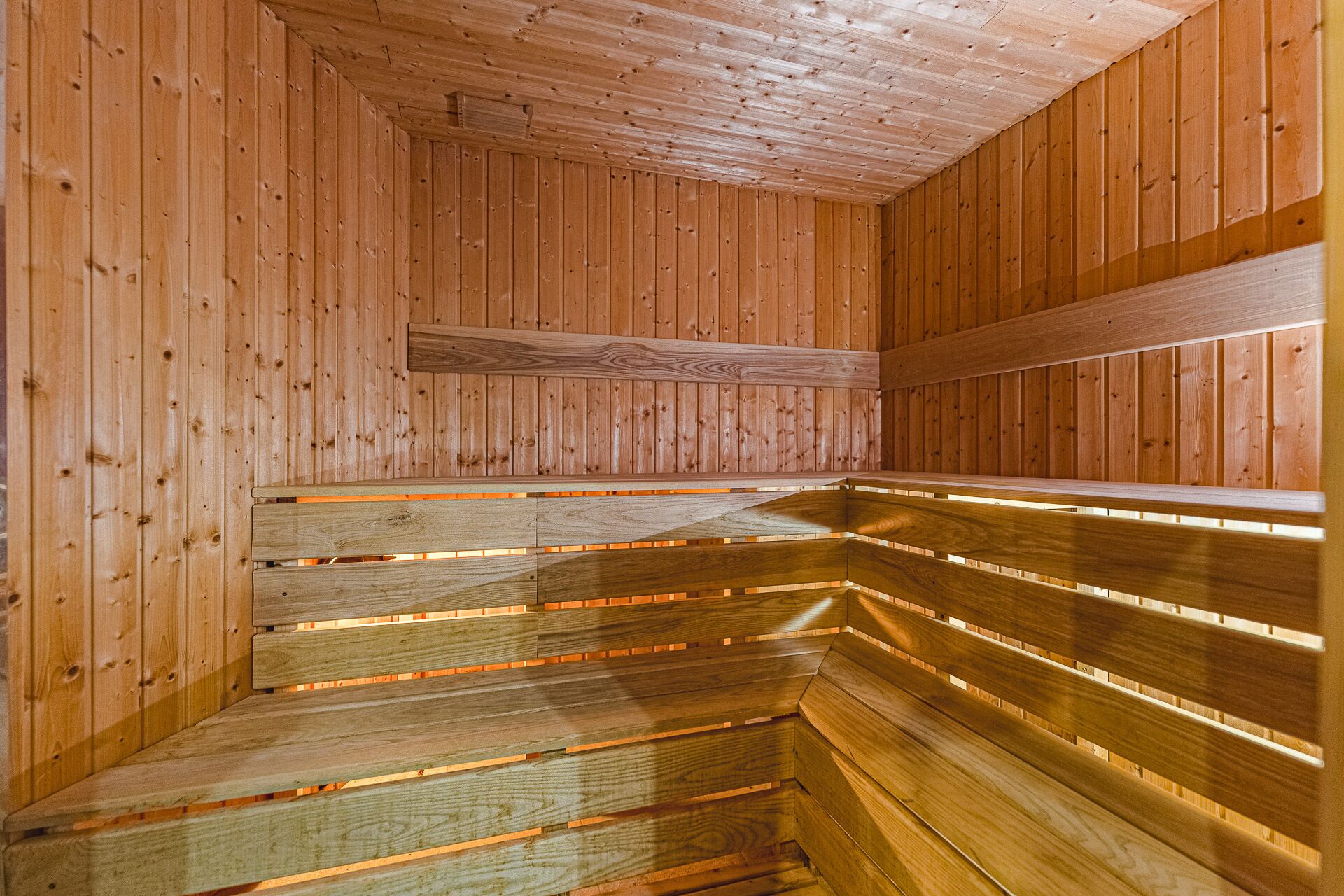 A wooden sauna with benches arranged in a semi-circular pattern.
