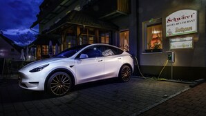 Un coche blanco estacionado frente a un hotel con un letrero que dice 'Schwörl Hotel-restaurant Rothaus'.