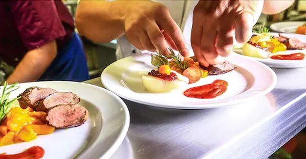 Un chef preparando comida en platos con diversos ingredientes.
