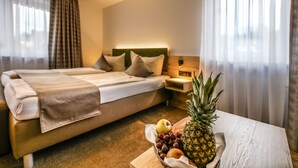 Una habitación de hotel con una cama, una mesita de noche y una mesa con frutero.